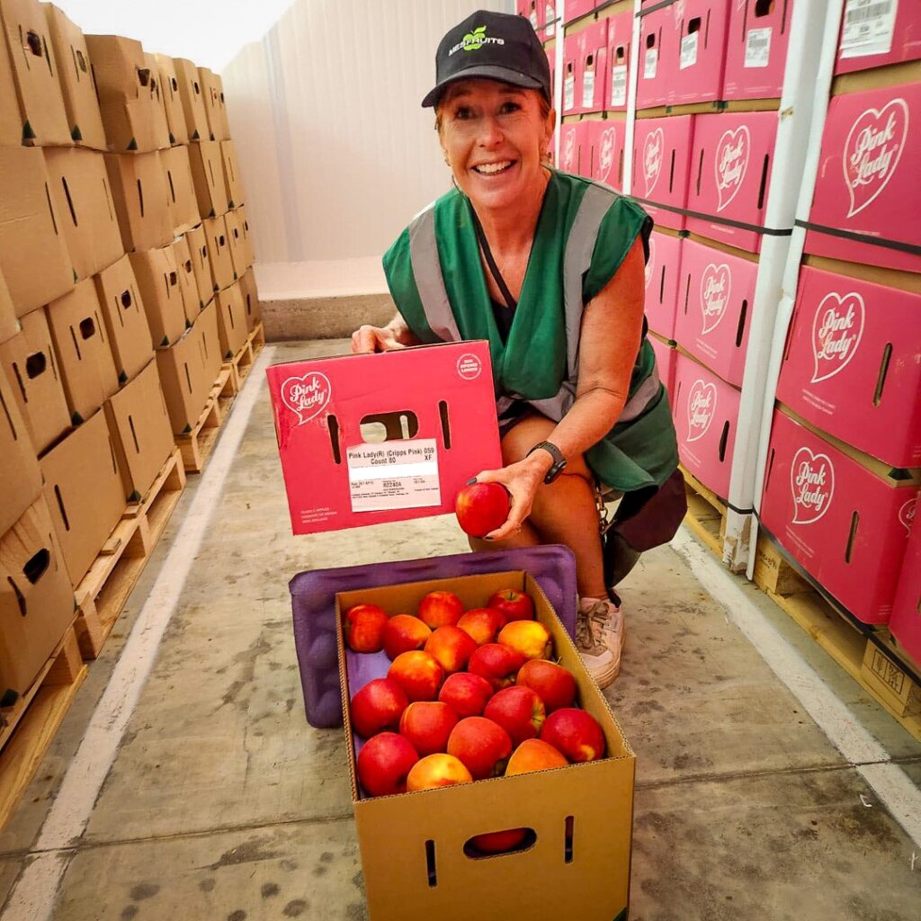 Our Director, Cherie with a carton of Pink Lady apples in France